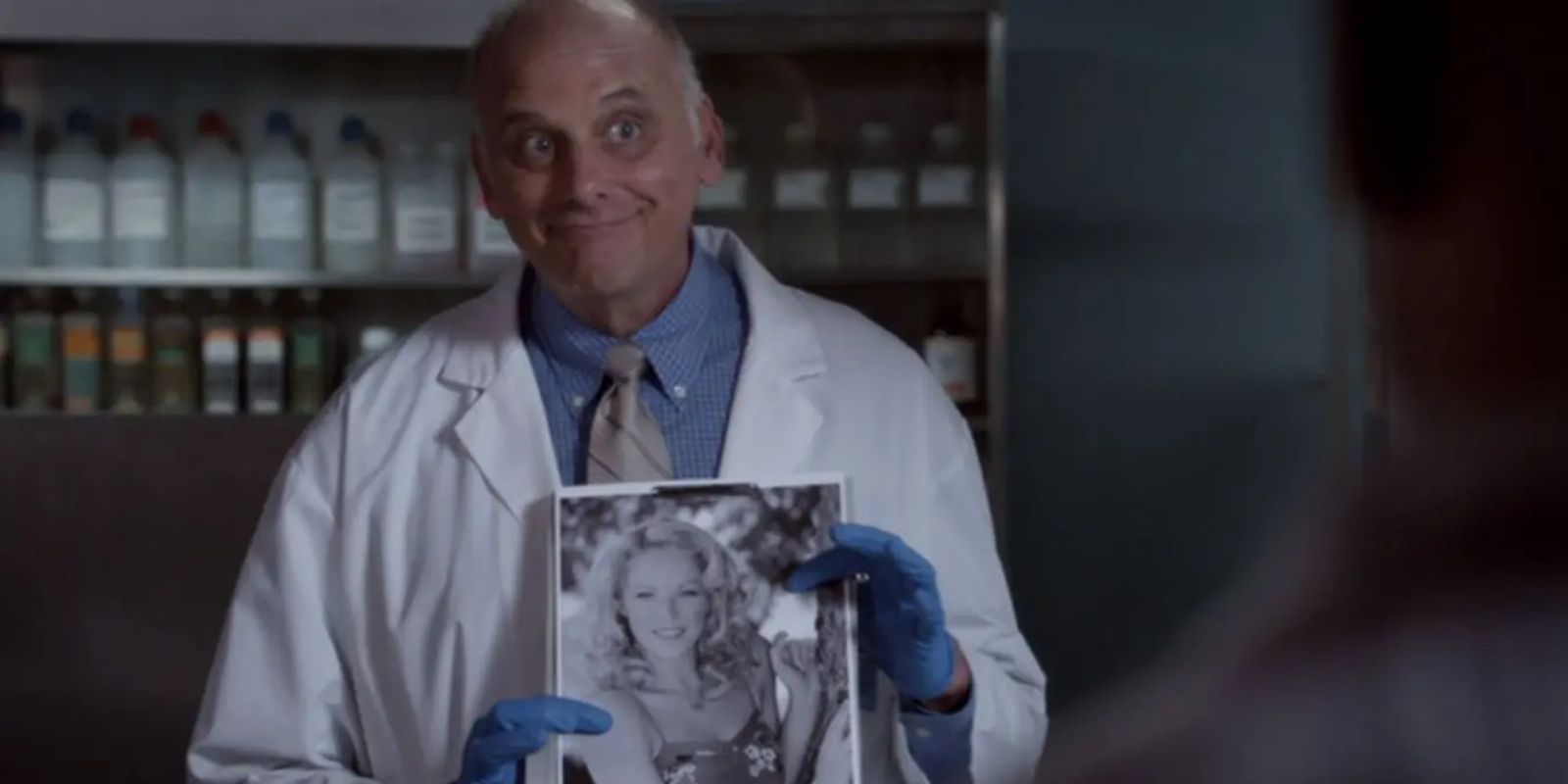Woody Strode holds up a black and white photo in the morgue in Psych