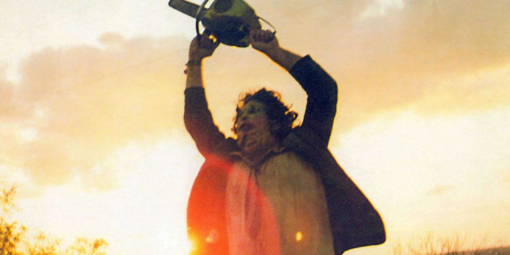 Leatherface holding chainsaw over his head in The Texas Chain Saw Massacre