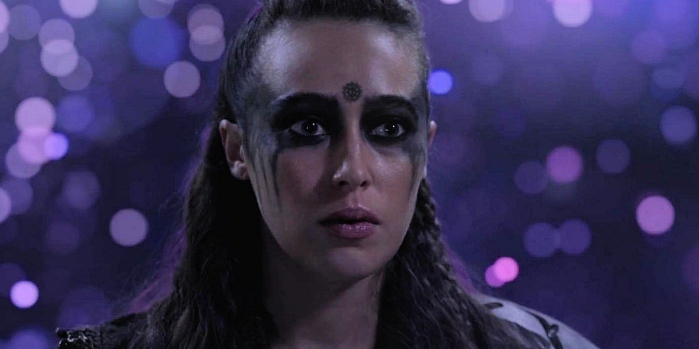 Lexa looks worried with black paint on her face in The 100.