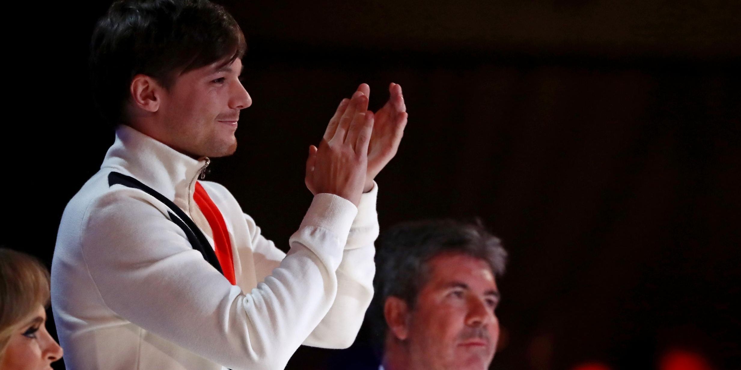 Louis Tomlinson claps for a contestant in X-Factor