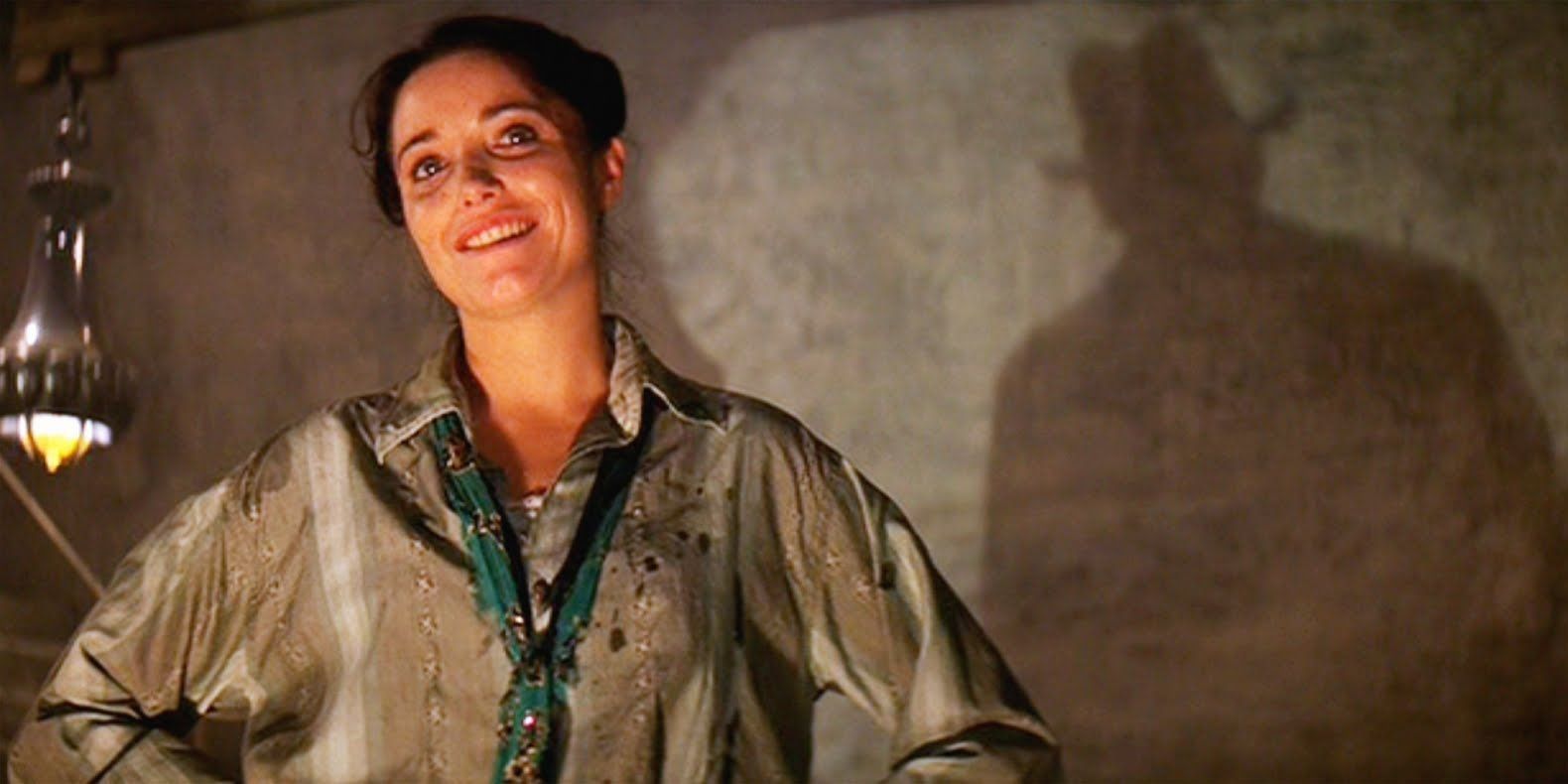 Marion Ravenwood smiling with her hands on her waist in Raiders of the Lost Ark