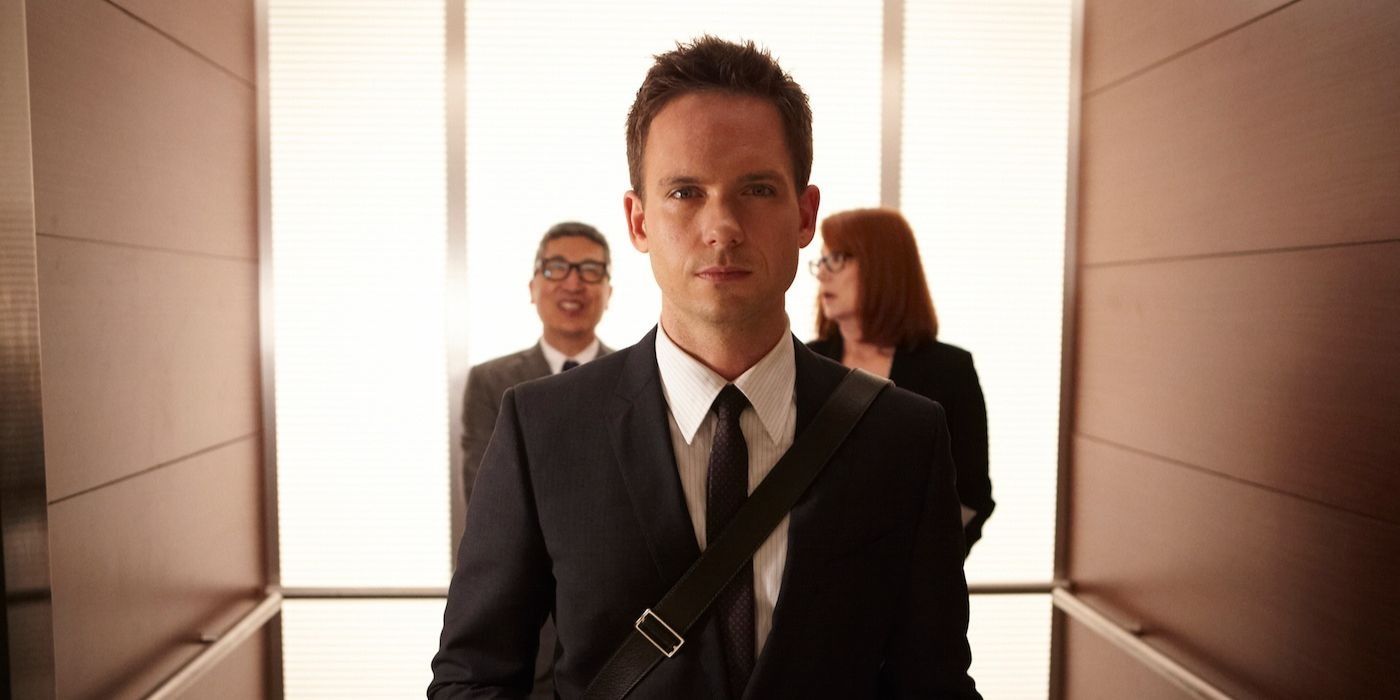 Mike Ross from Suits up close to the camera with two other people in the background