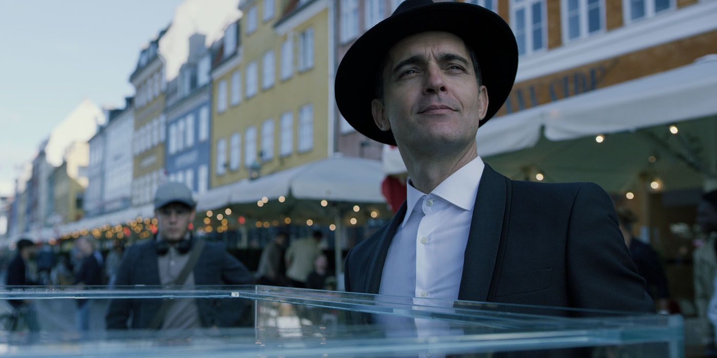 An image of Berlin wearing a hat and looking at something off-screen in Money Heist.