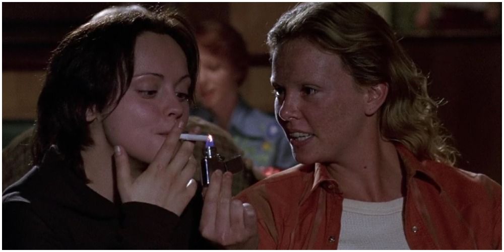 Woman Lighting Up Cigarette For Another Woman