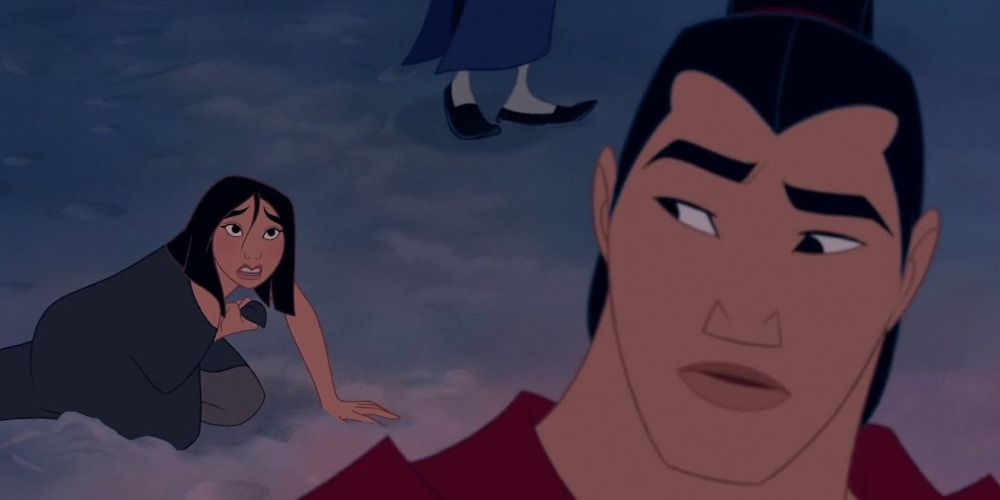 Shang walks away from Mulan who is on the ground wrapped in a blanket. 
