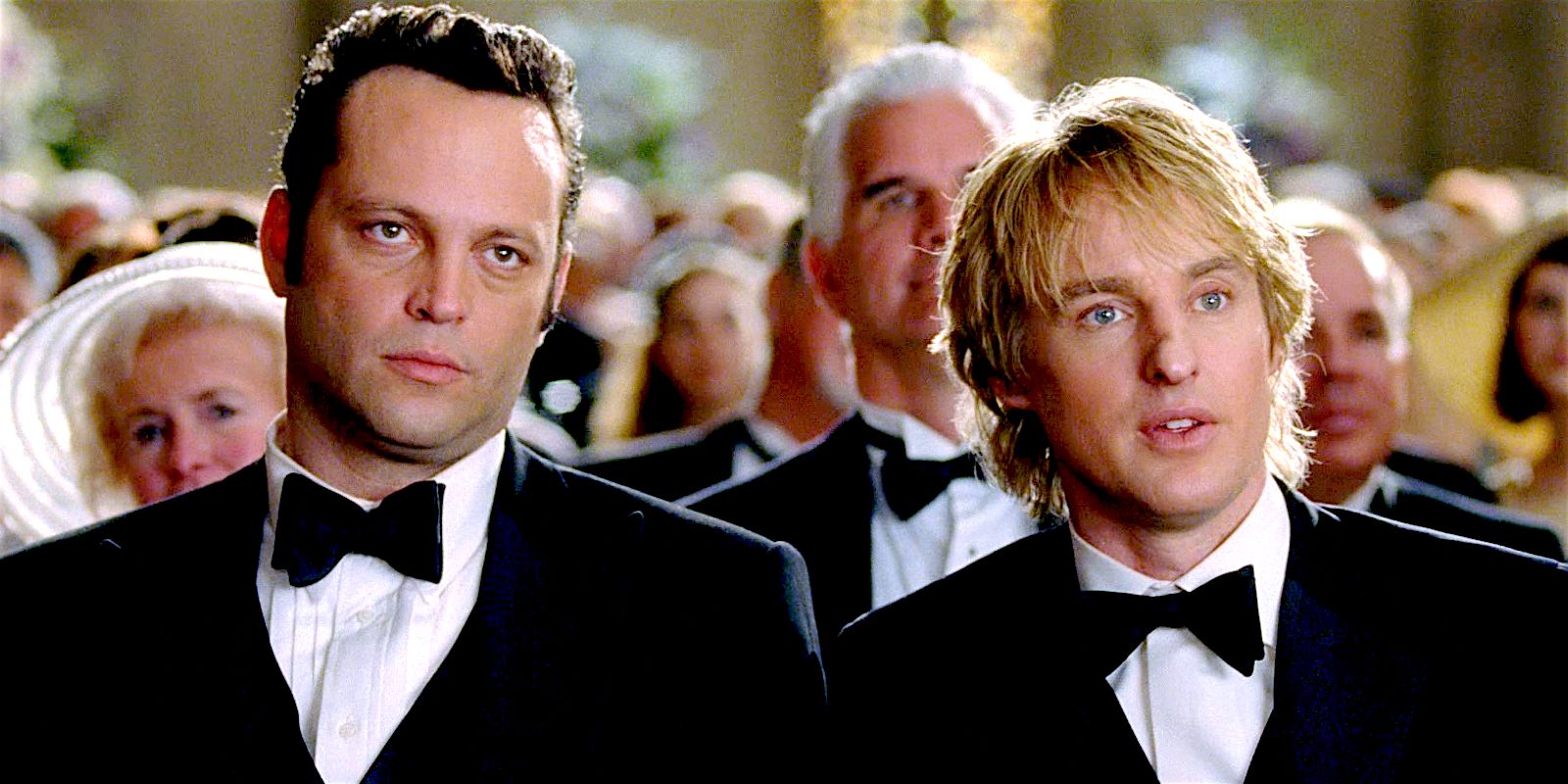 John and Jeremy look on blandly while attending a wedding in Wedding Crashers