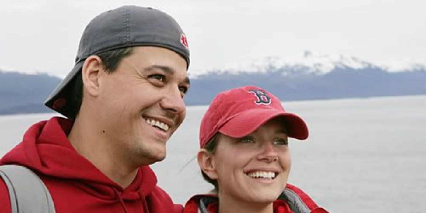 Rob and Amber smile in front of a misty skyline in The Amazing Race 7