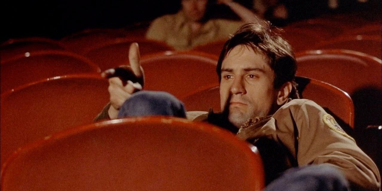 Robert De Niro sitting in a movie theater in Taxi Driver