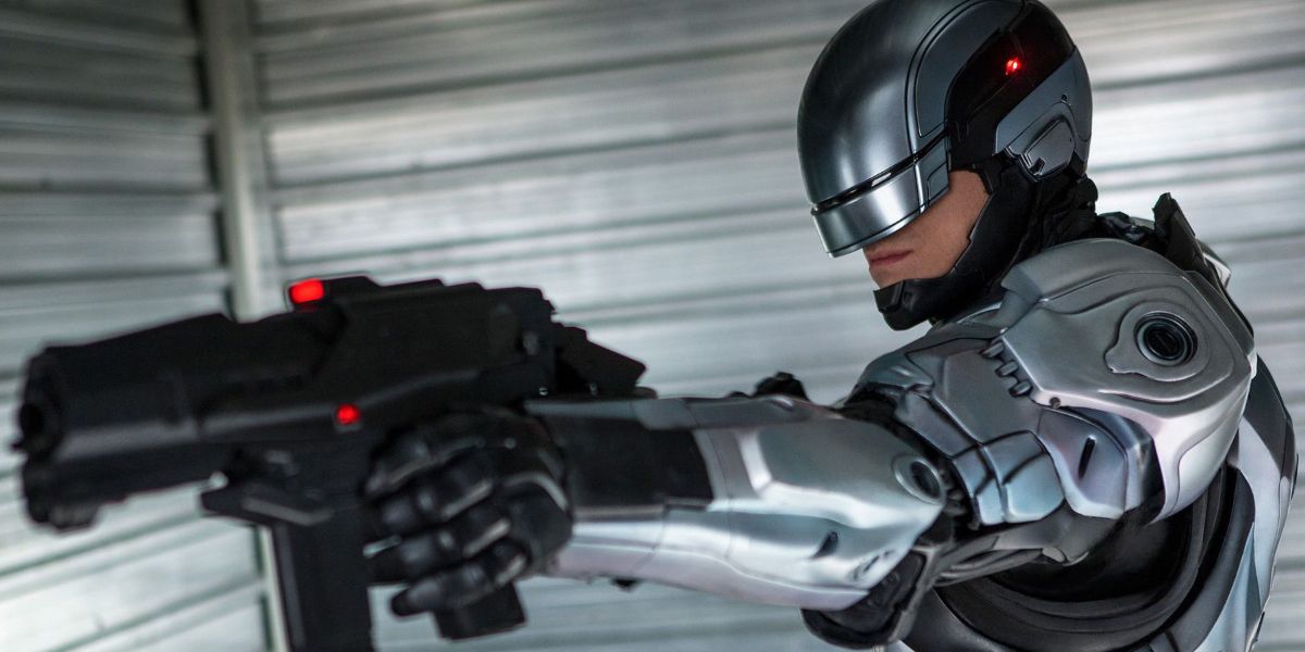 Joel Kinnaman as Robocop pointing a gun