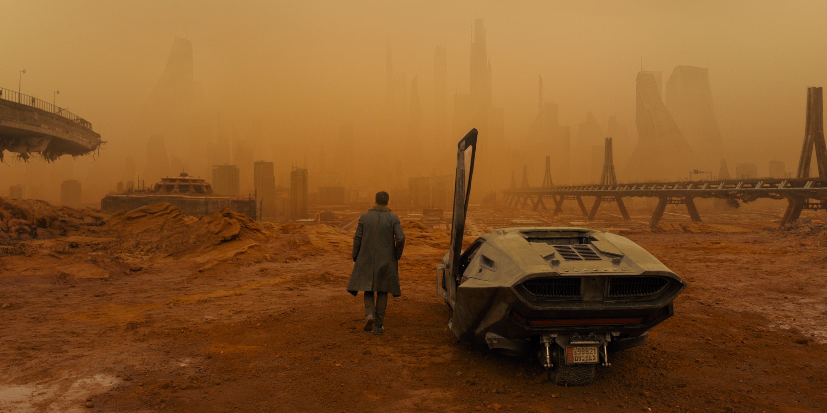 Ryan Gosling walking across a barren wasteland in Blade Runner 2049