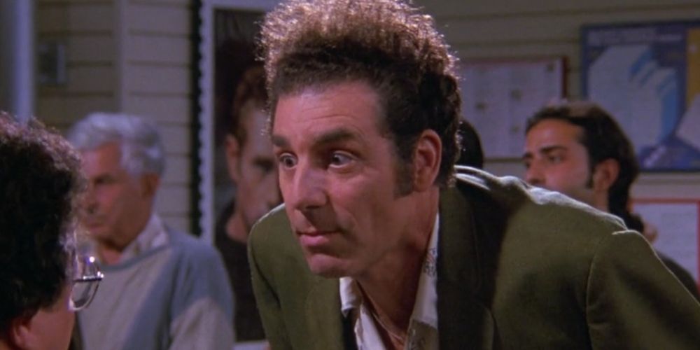 Cosmo Kramer with his eyes wide, leaning over a table