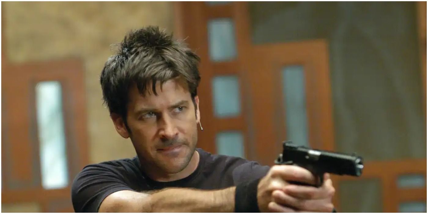 Brown haired man in black t shirt with gun