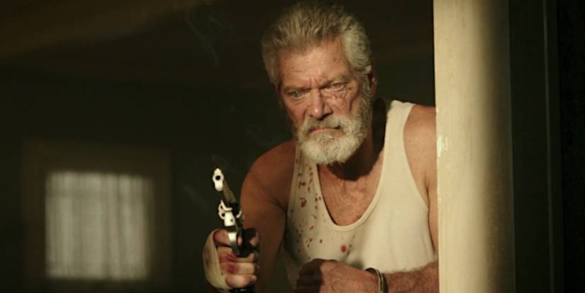 Stephen Lang as the Blind Man holding a gun and grimacing in Don't Breathe