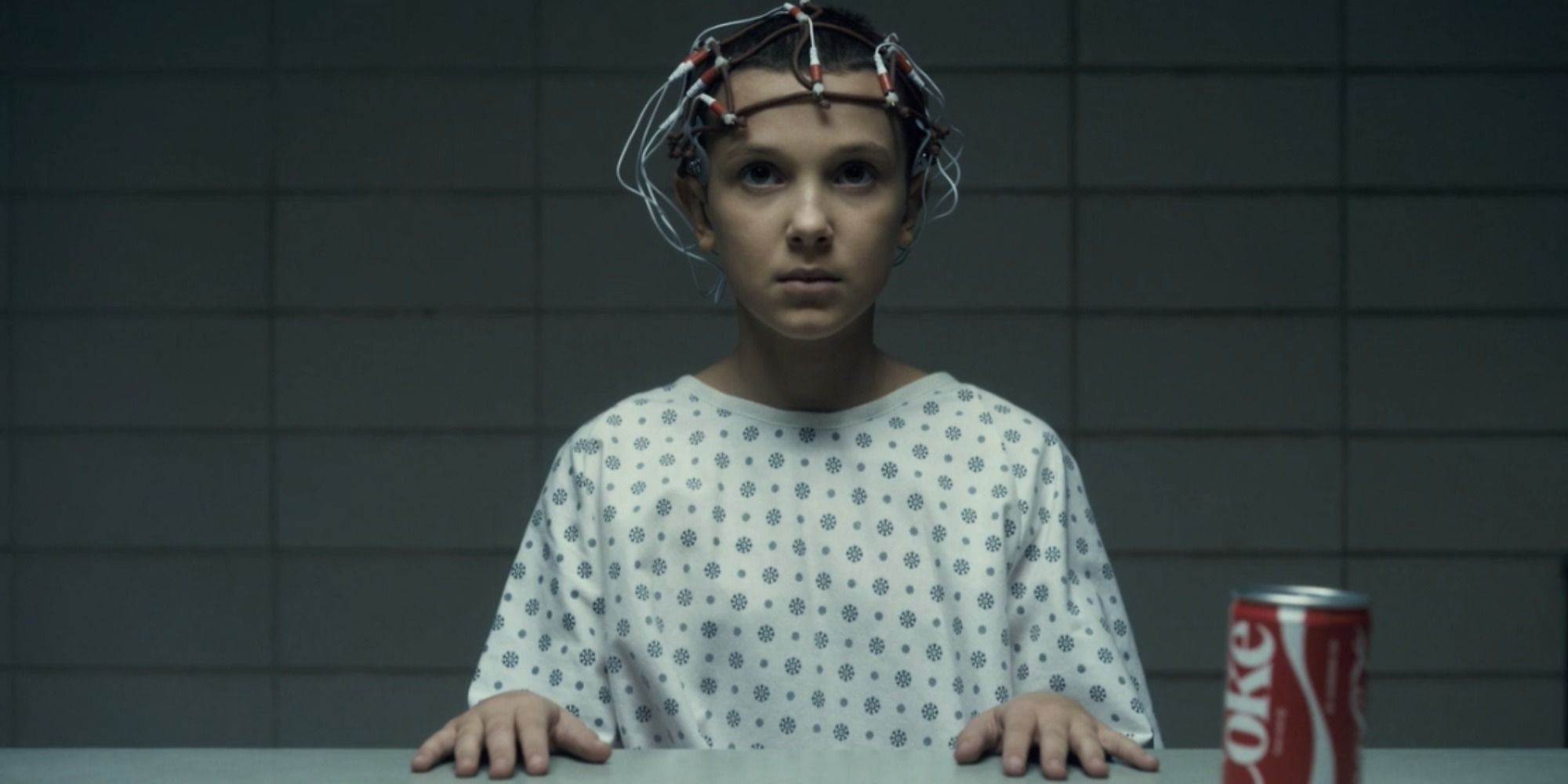 A screenshot of Eleven being tested by Dr. Brenner of her psychokinetic abilities in Stranger Things