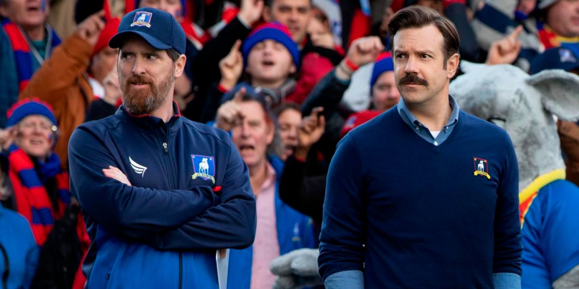 Ted Lasso and Coach Beard standing next to each other at a match