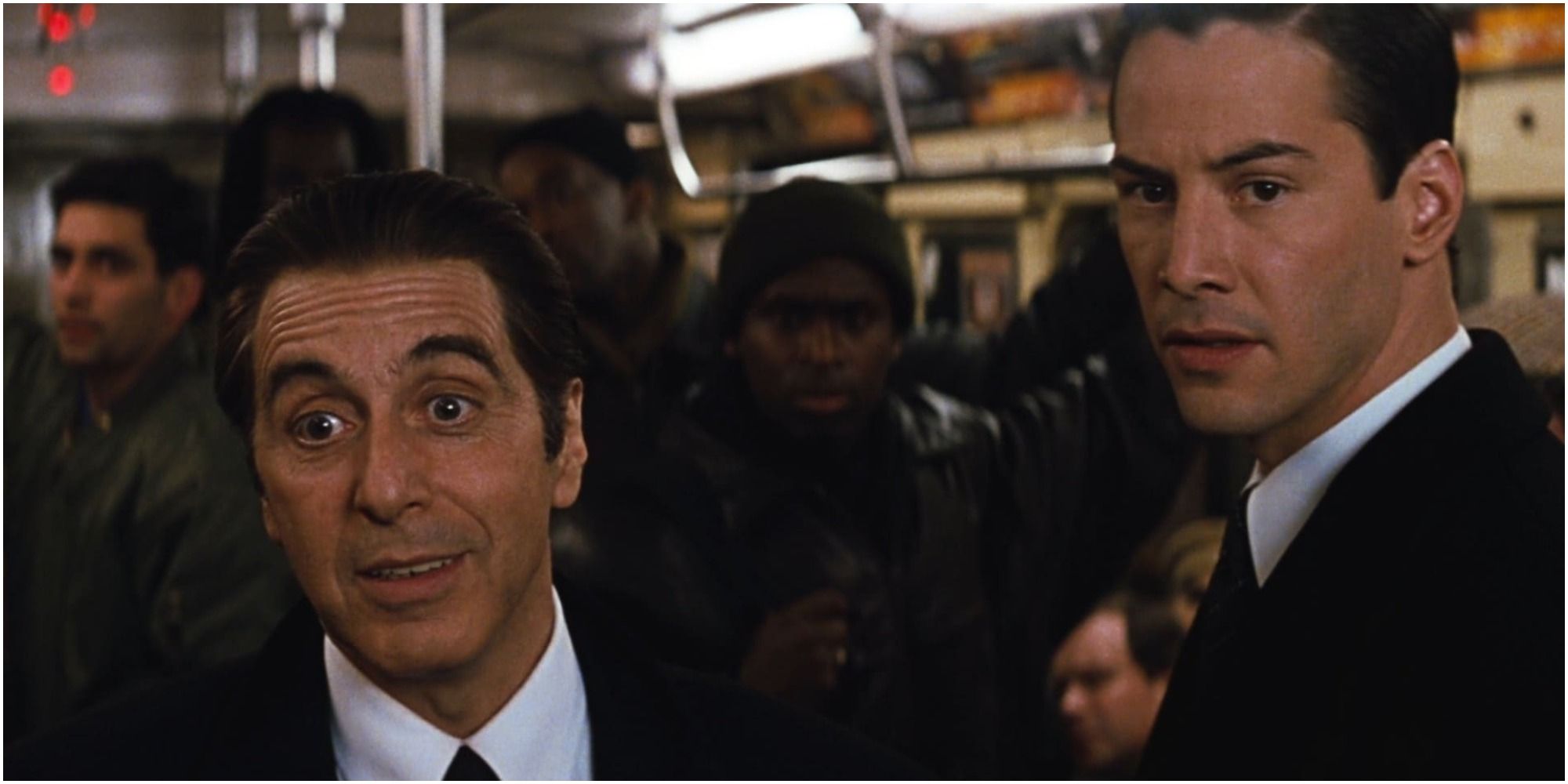 A screenshot of Al Pacino's John Milton and Keanu Reeves' Kevin Lomax in a subway from The Devil's Advocate