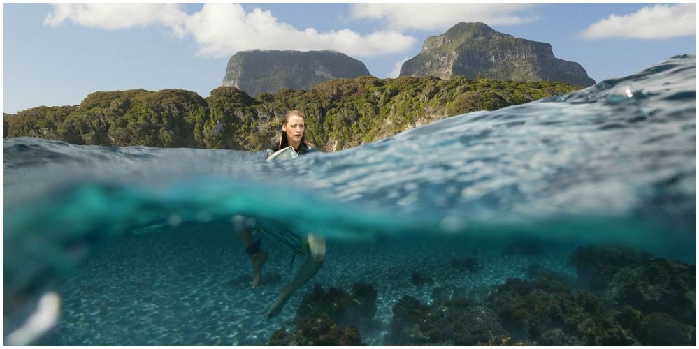 Woman sitting on a surfboard in the ocean