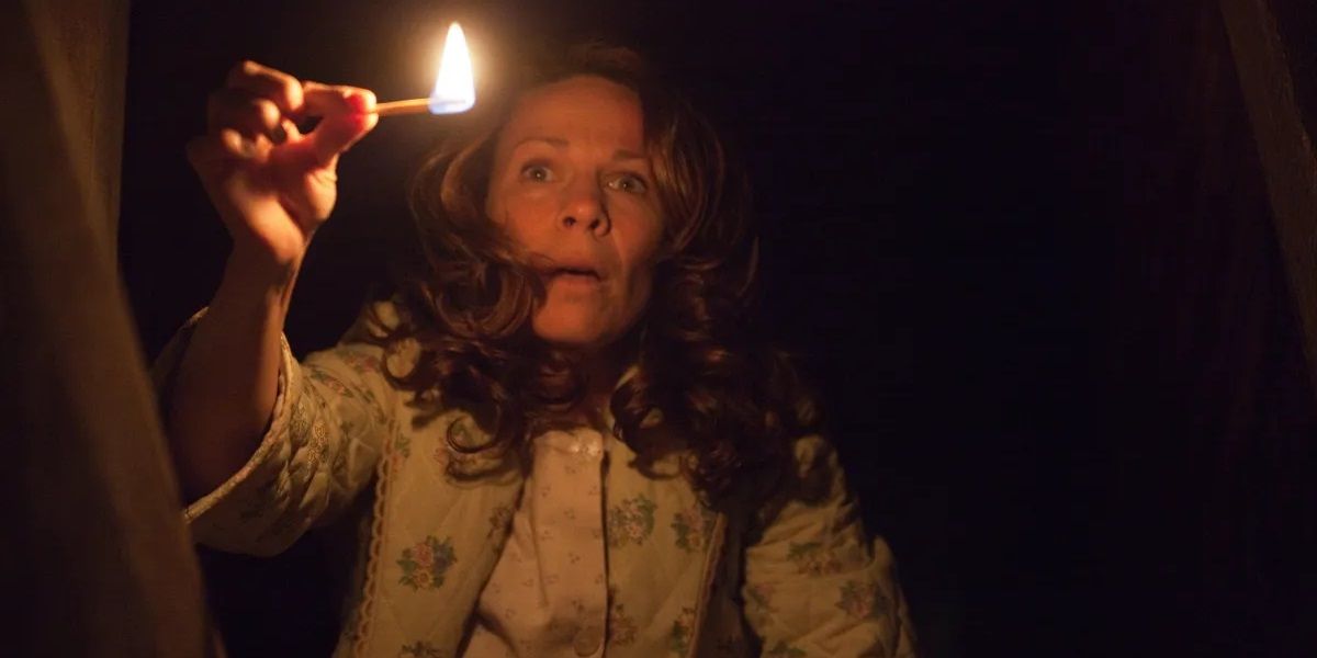 Carolyn Perron holds a match in a dark space in The Conjuring.