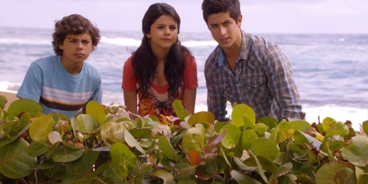 The Russo siblings hiding behind a shrub on the beach in Wizards of Waverly Place: The Movie (2009)