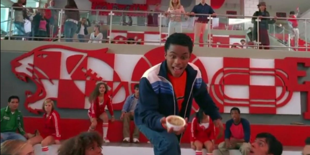 Zeke stands up in the cafeteria with his dessert, announcing his love for baking, in High School Musical