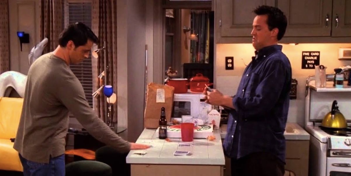 Joey and Chandler playing Cups a game Chandler made up to give money to Joey for when he moves in with Monica