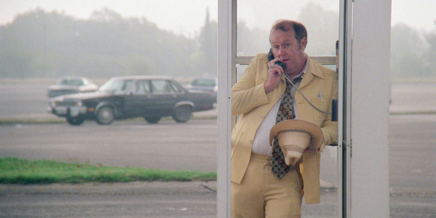 Lorren Visser in yellow suit talking on phone in phone booth in Blood Simple