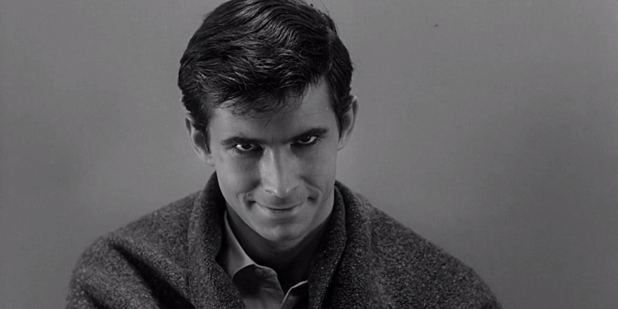 Norman Bates smiles at the camera in Psycho.