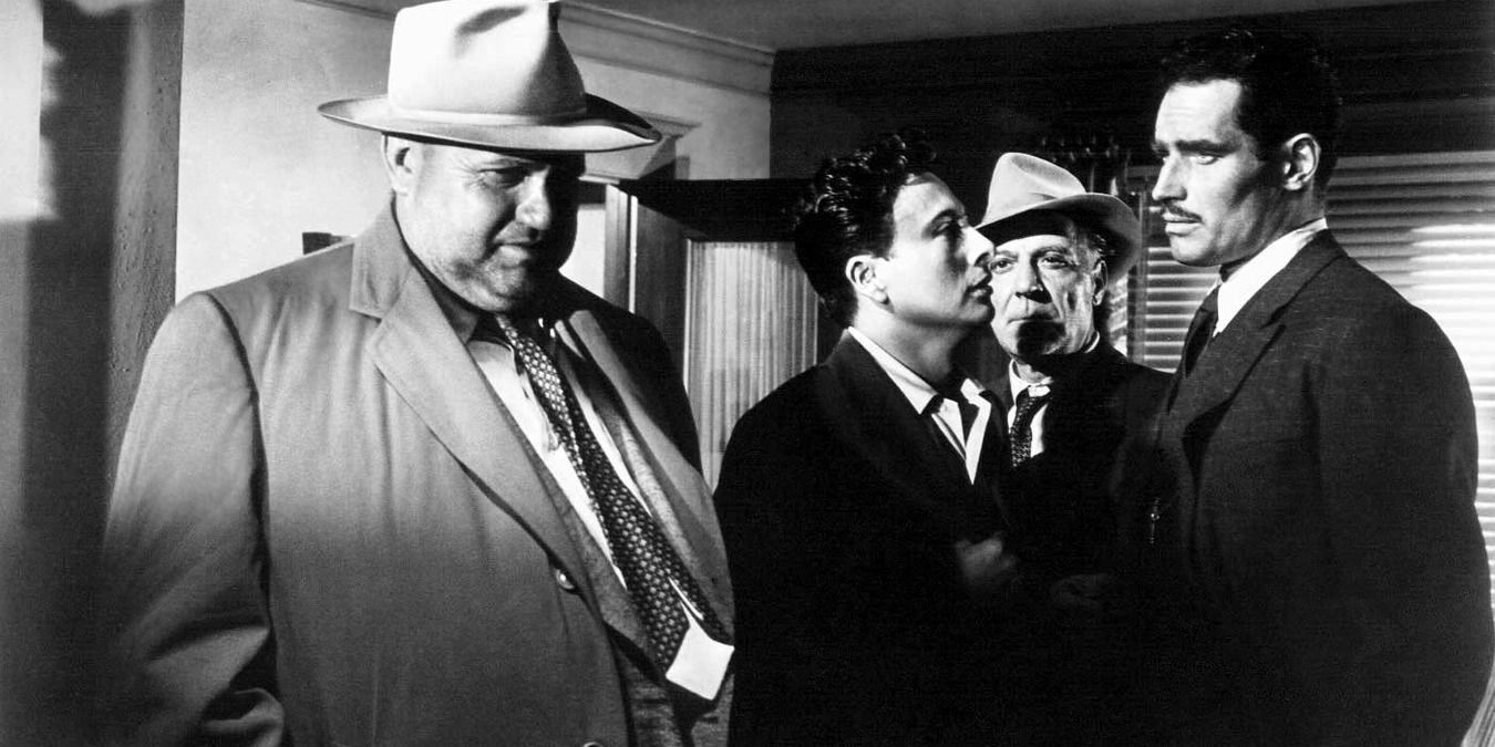 Orson Welles and Charton Heston in A Touch of Evil standing side by side and talking.