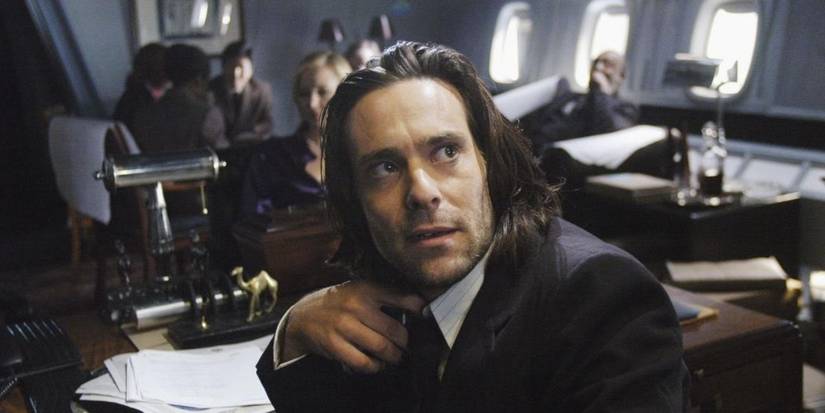Gaius Baltar from Battlestar Galactica looking behind him with mouth slightly open.