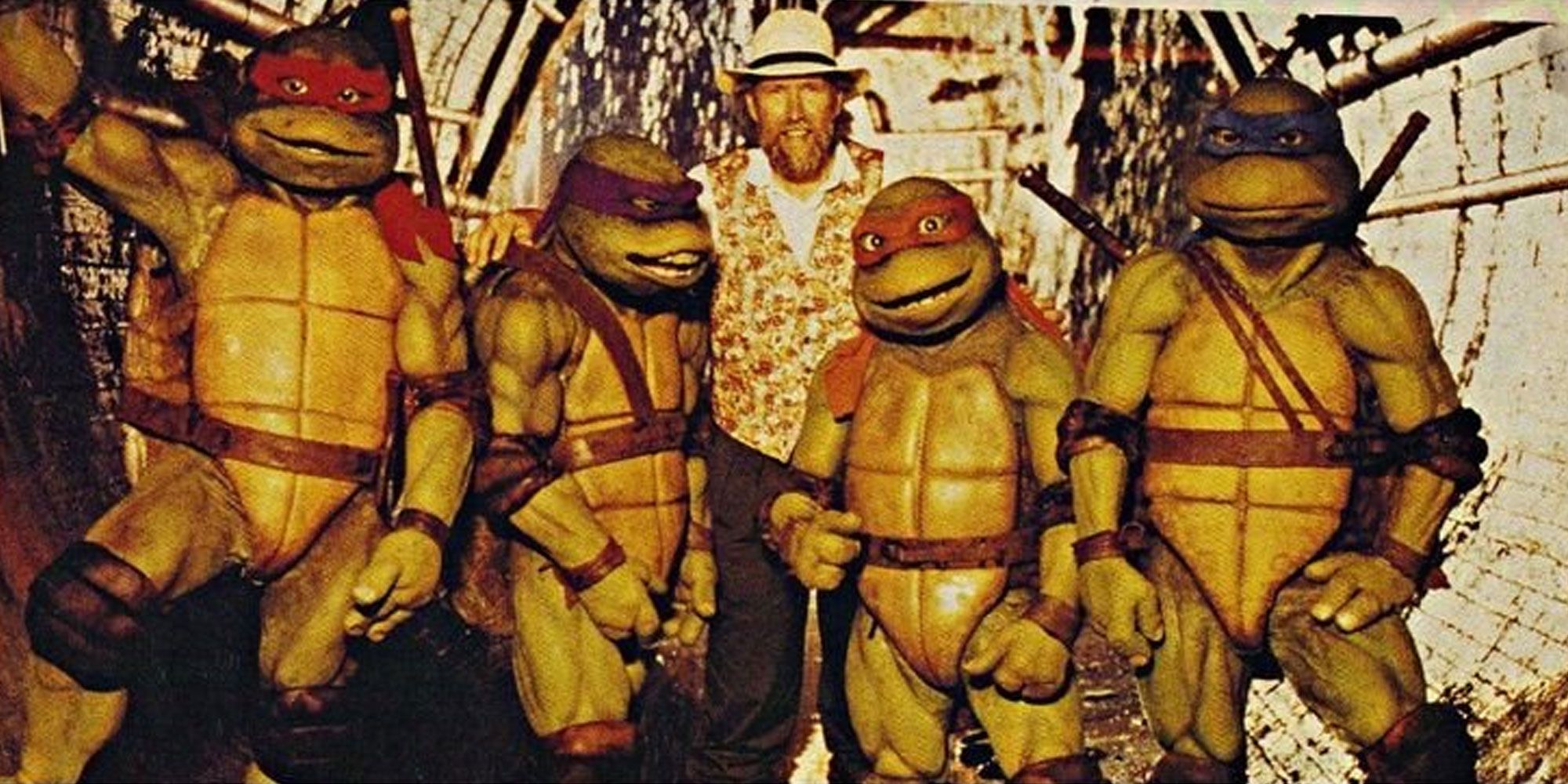 Jim Henson stands with the original live action Ninja Turtles in costume