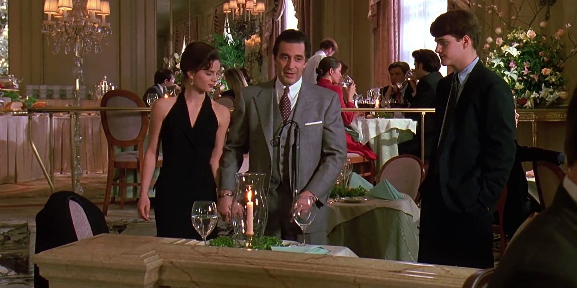 Uma imagem de Frank Slade caminhando para uma mesa de jantar em um perfume de uma mulher