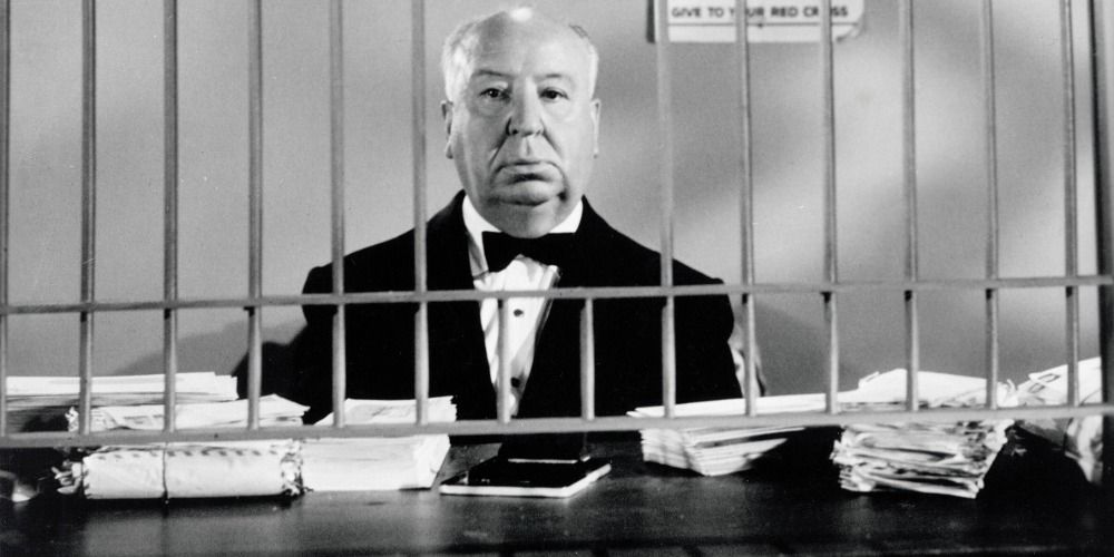 Alfred Hitchcock behind bars looking at the camera 