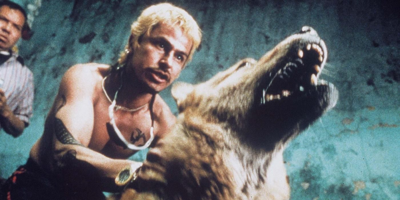 A man holds back a barking dogs in Amores perros