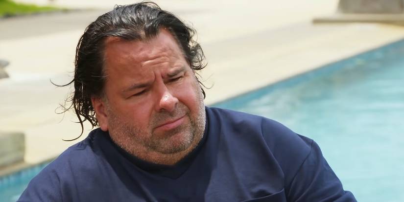 Big Ed Brown from 90 Day Fiancé near a pool in blue shirt looking sad