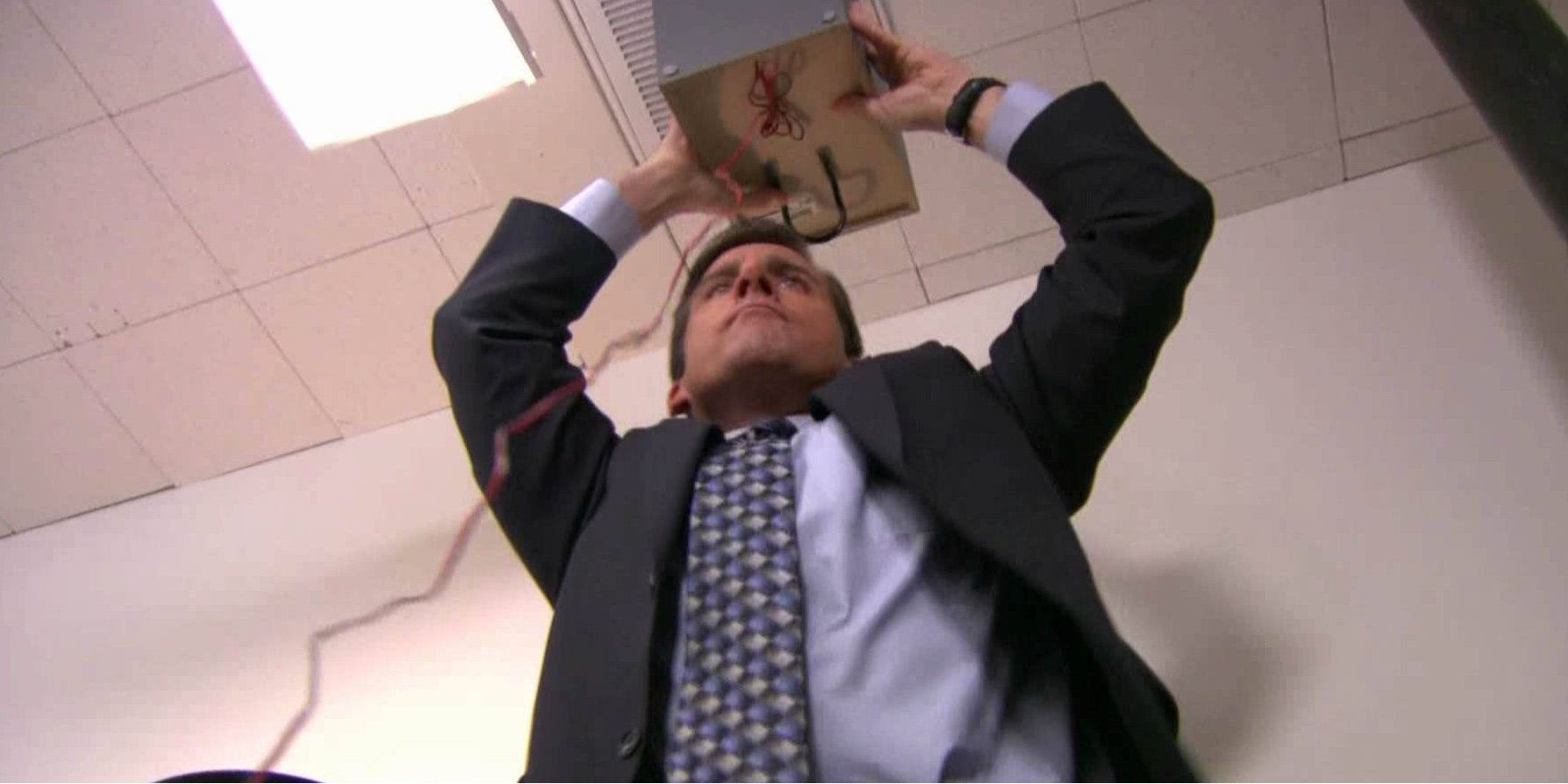 Michael Scott holding a speaker to the ceiling on The Office