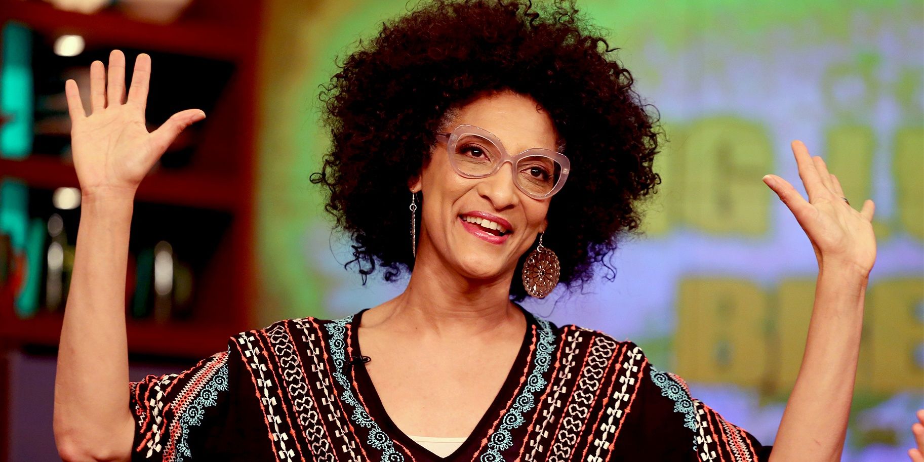 Carla Hall smiling and raising her arms in Top Chef.