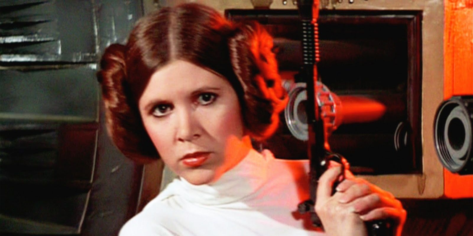 Carrie Fisher as Leia Organa holding a blaster