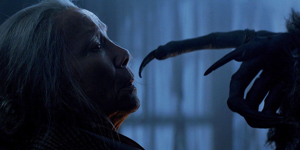 Krampus extends a claw toward a woman's face