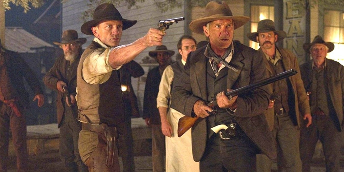Daniel Craig and Harrison Ford holding guns in Cowboys and Aliens.