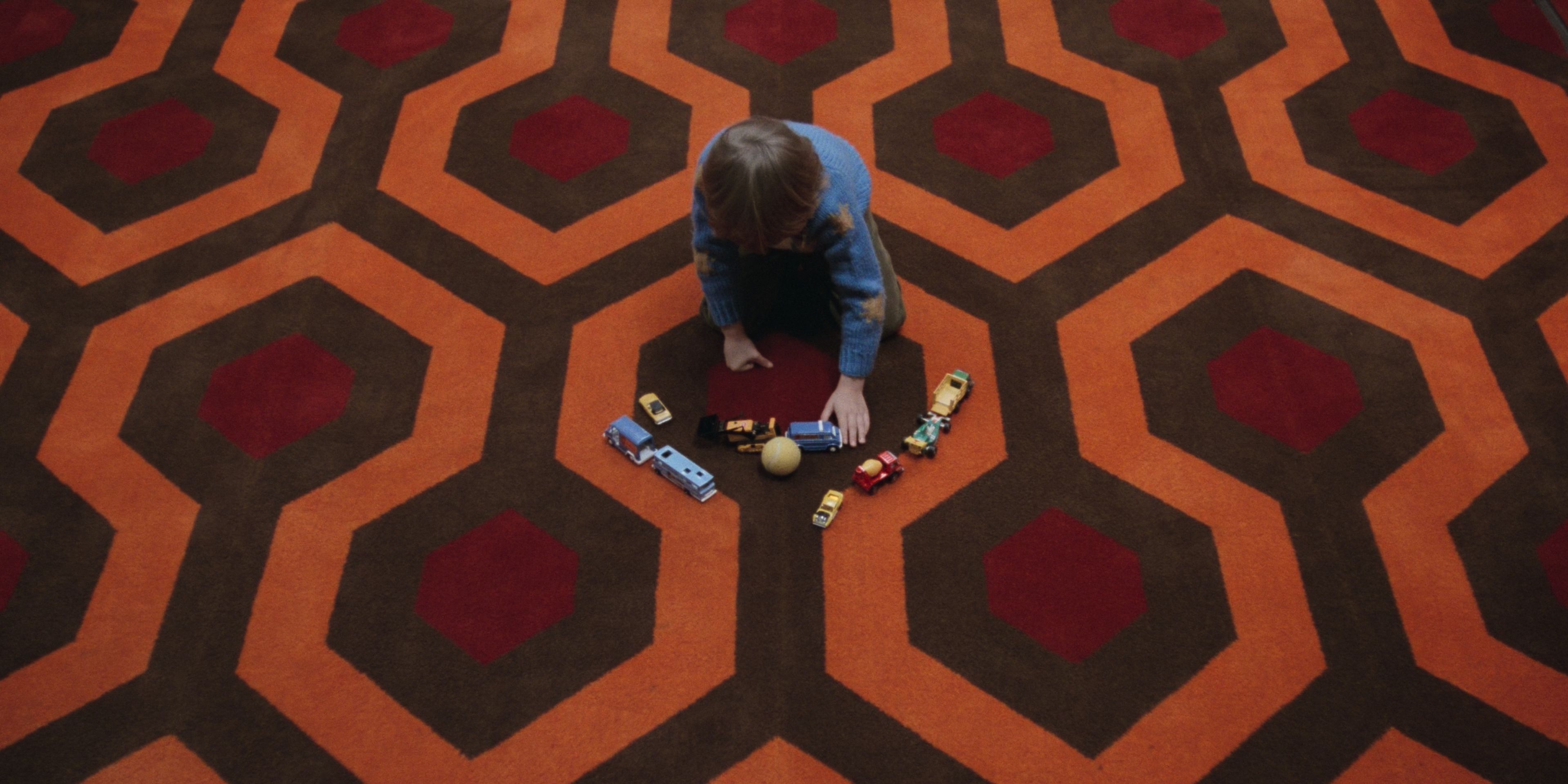 Danny jugando con sus juguetes en la alfombra del Hotel Overlook en El Resplandor