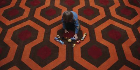 Danny playing with his toys on the Overlook Hotel carpet in The Shining