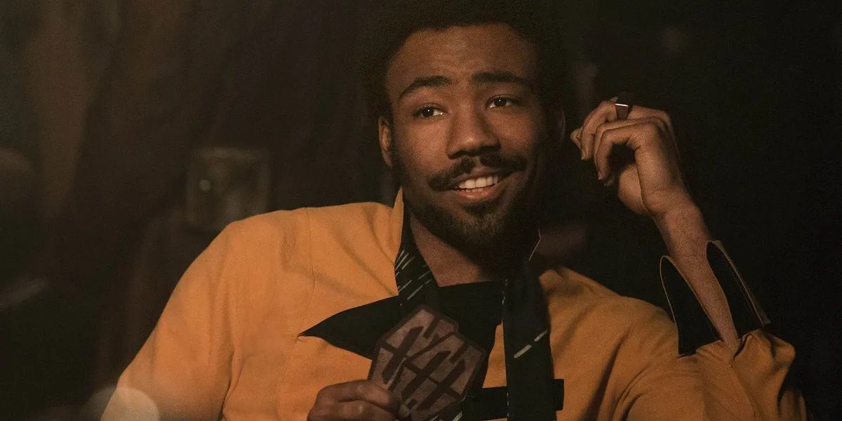 Lando Calrissian smiles while looking on from Solo A Star Wars Story