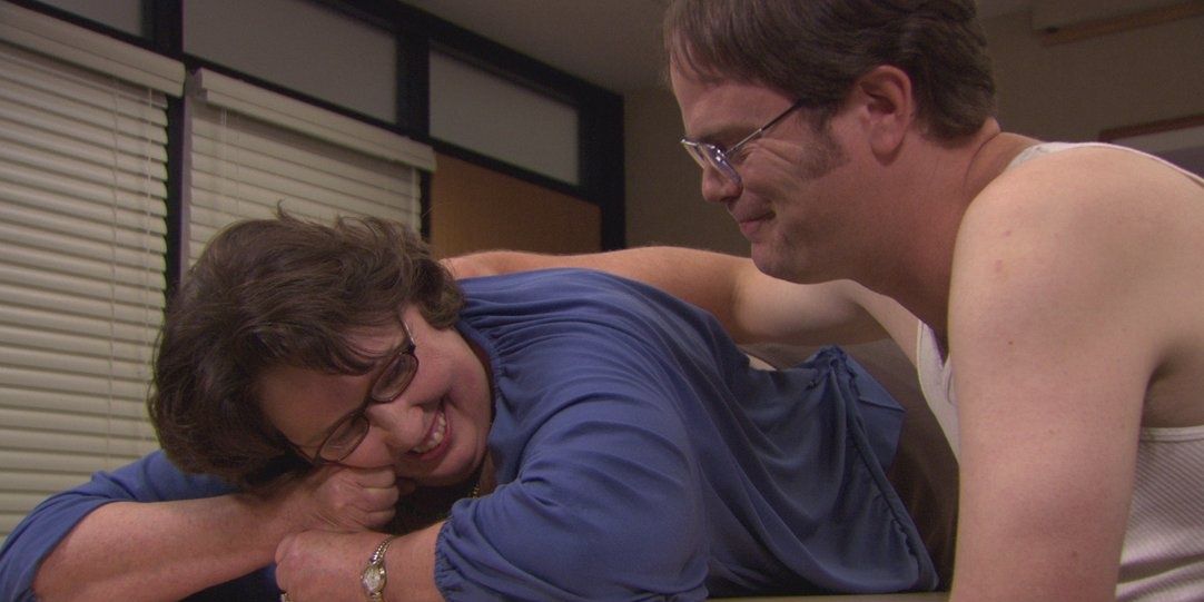 Dwight helps Phyllis with her aching back on the office
