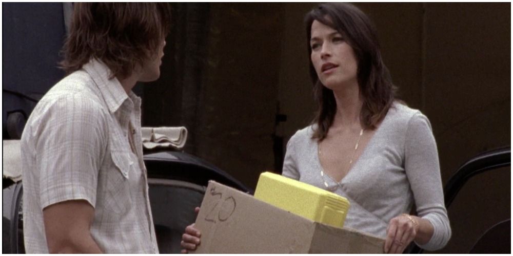 dark haired man and brunette woman holding a box
