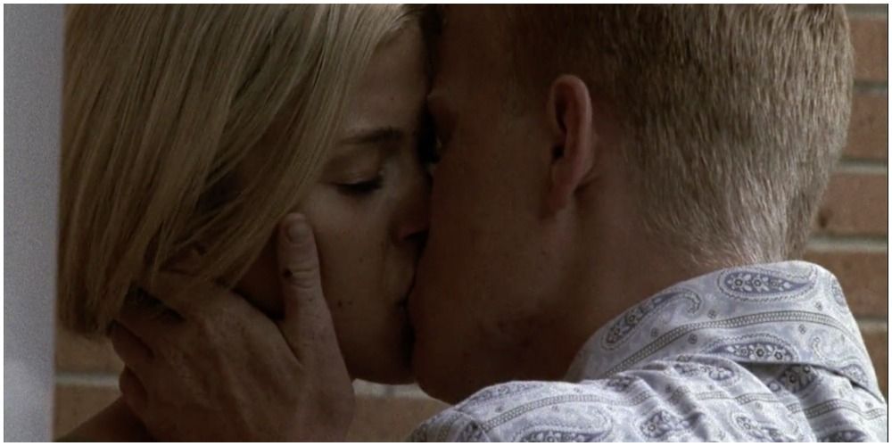 blonde girl being kissed by blonde guy in plaid shirt