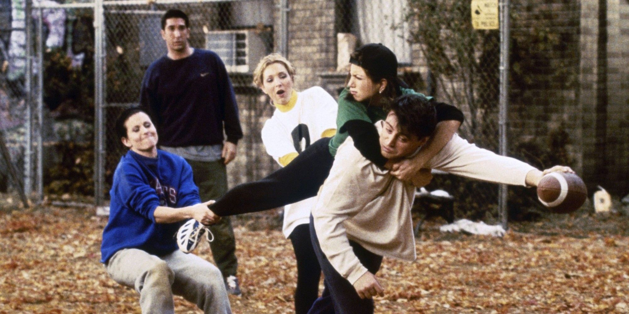 Rachel, Monica and Phoebe try to stop Joey from scoring in a game of football in Friends