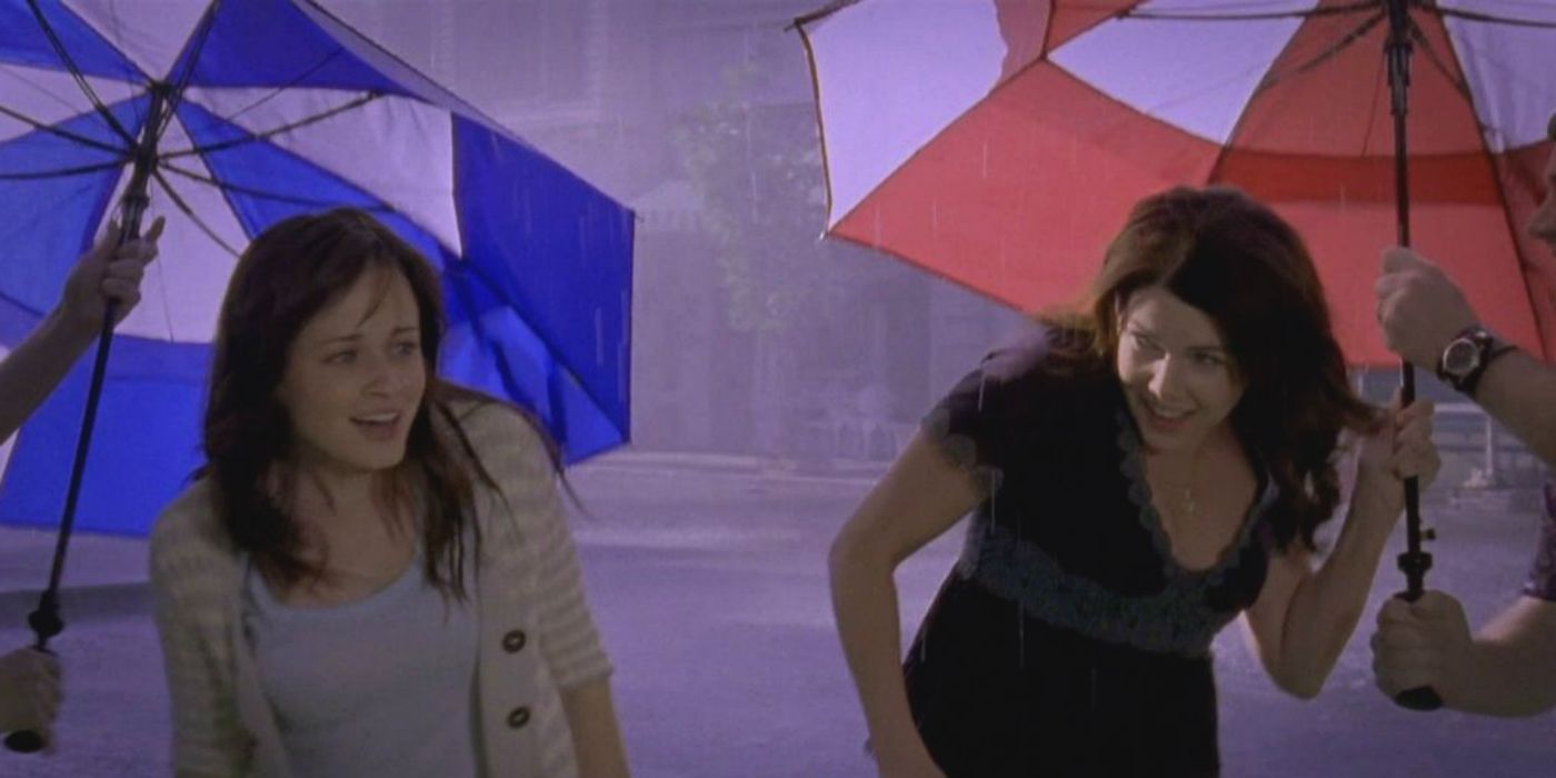 Rory and Lorelai smiling with umbrellas on Gilmore Girls