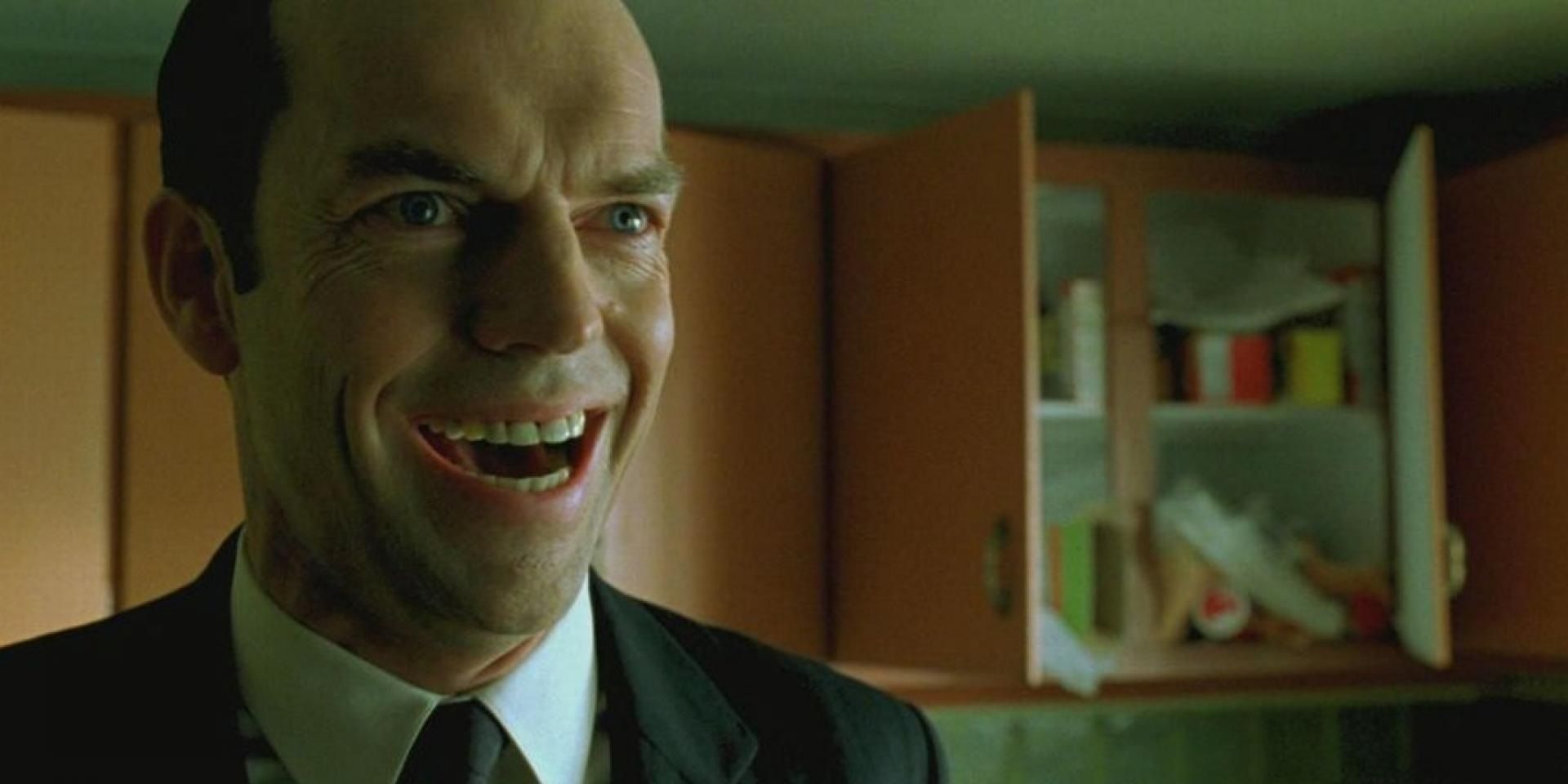 Hugo Weaving as Agent Smith smiling in The Matrix