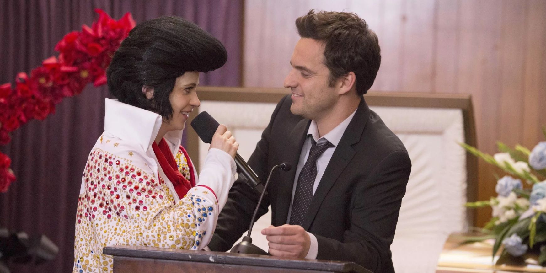 Jess sings as Elvis while Nick stands at the podium for his father's funeral service in the New Girl episode Chicago