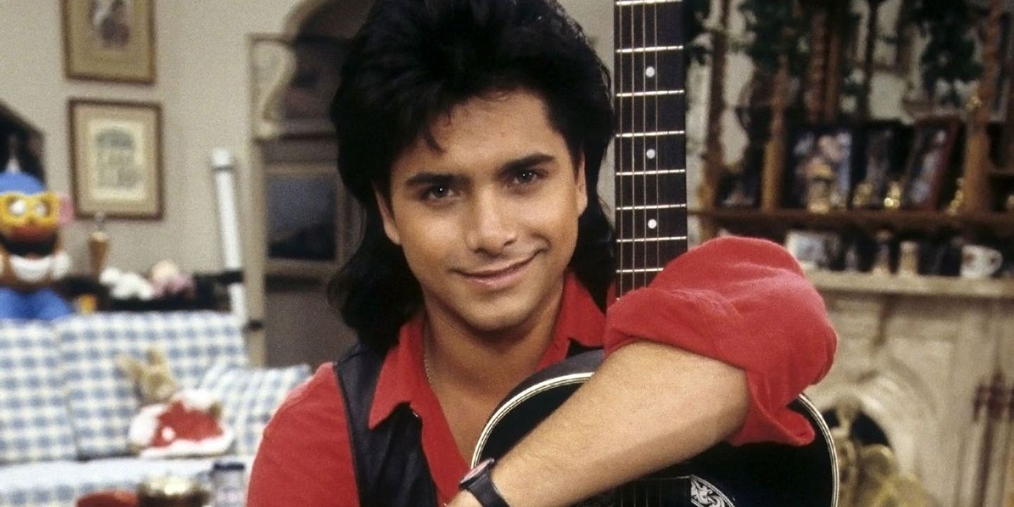 Uncle Jesse has a mullet and holds up his guitar.
